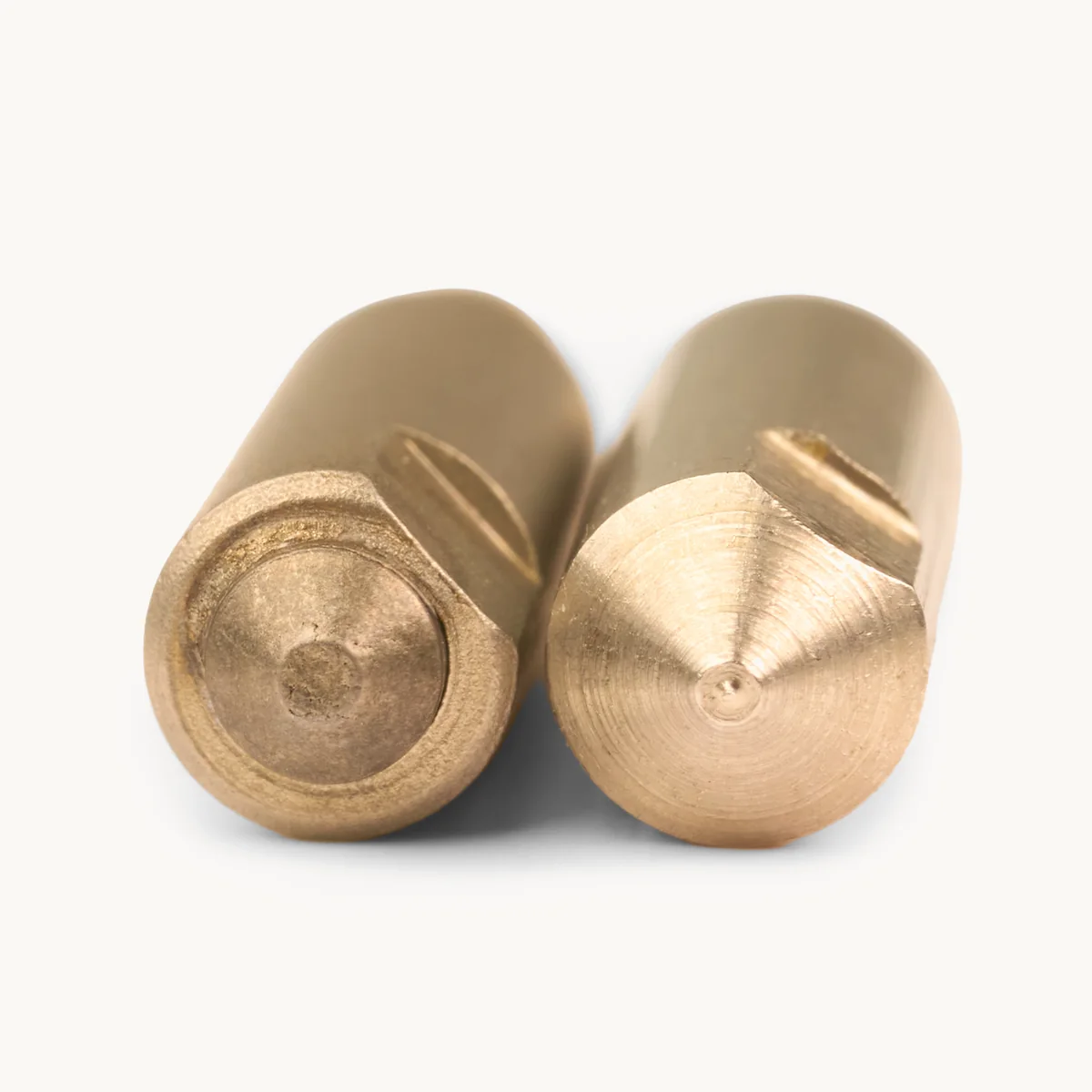 Two spike tips side by side: a tungsten carbide insert and a machined stainless steel point